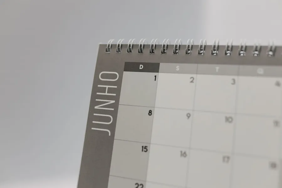 A spiral-bound wall calendar showing a month laid out in a grid.